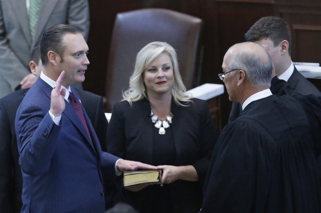 Charles McCall taking the oath of office as governor, political event, law official, government ceremony, political leadership.